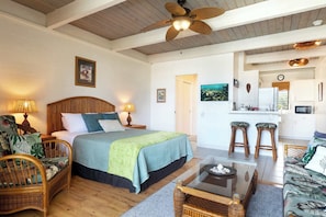 A spacious room with a large bed, a dining area, and a kitchen.