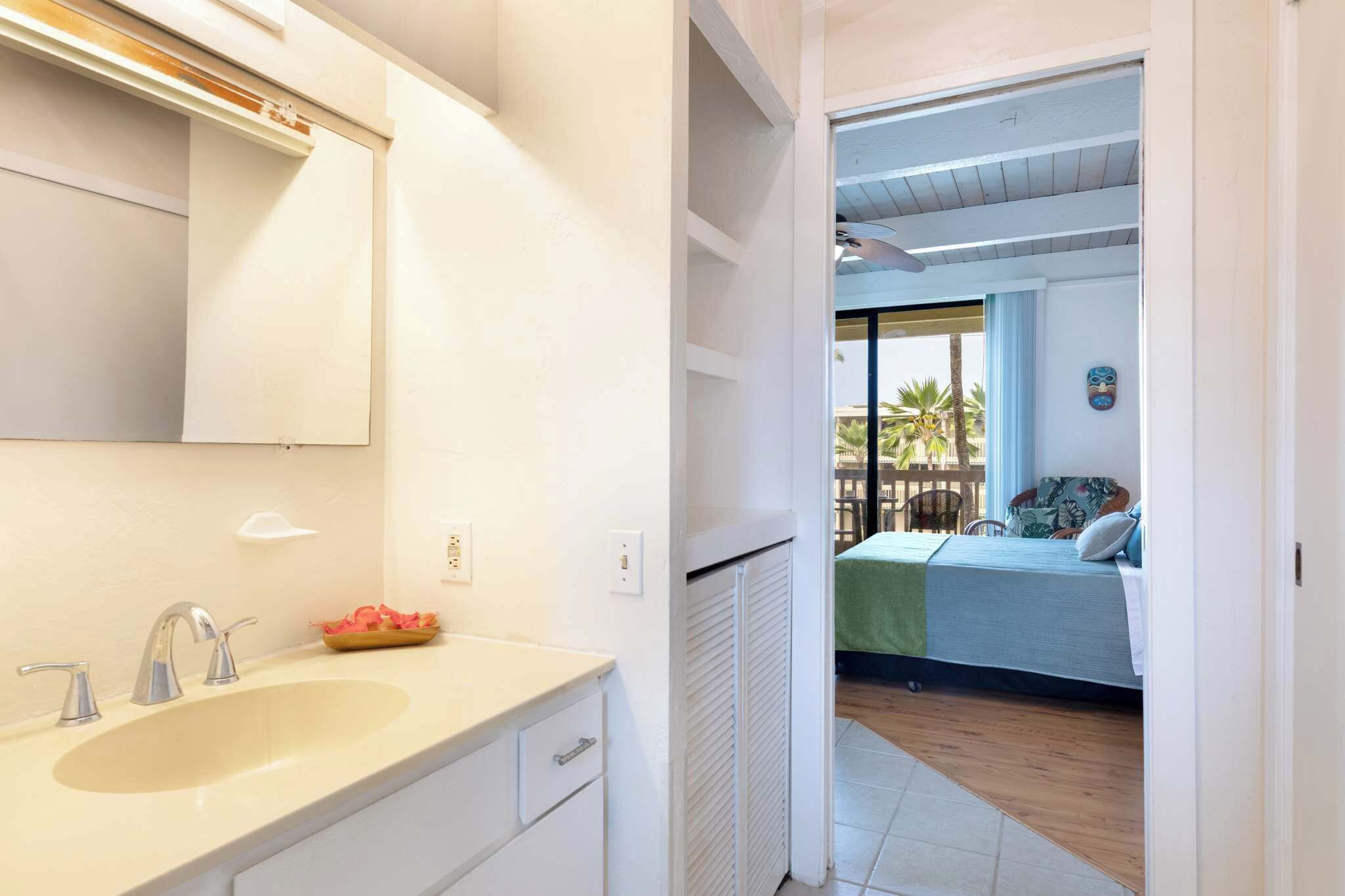 A bathroom with a sink, mirror, and towel rack.