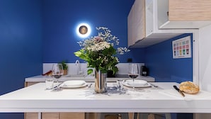 Une table à manger dressée avec des assiettes, des verres et un vase de fleurs.