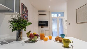 Une table de petit-déjeuner avec des fruits, du jus et des croissants.