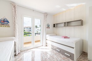 Une chambre avec un lit, une armoire, une étagère et une vue sur l’extérieur.