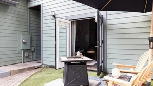 Une terrasse avec un barbecue, du mobilier d’extérieur et un espace abrité.