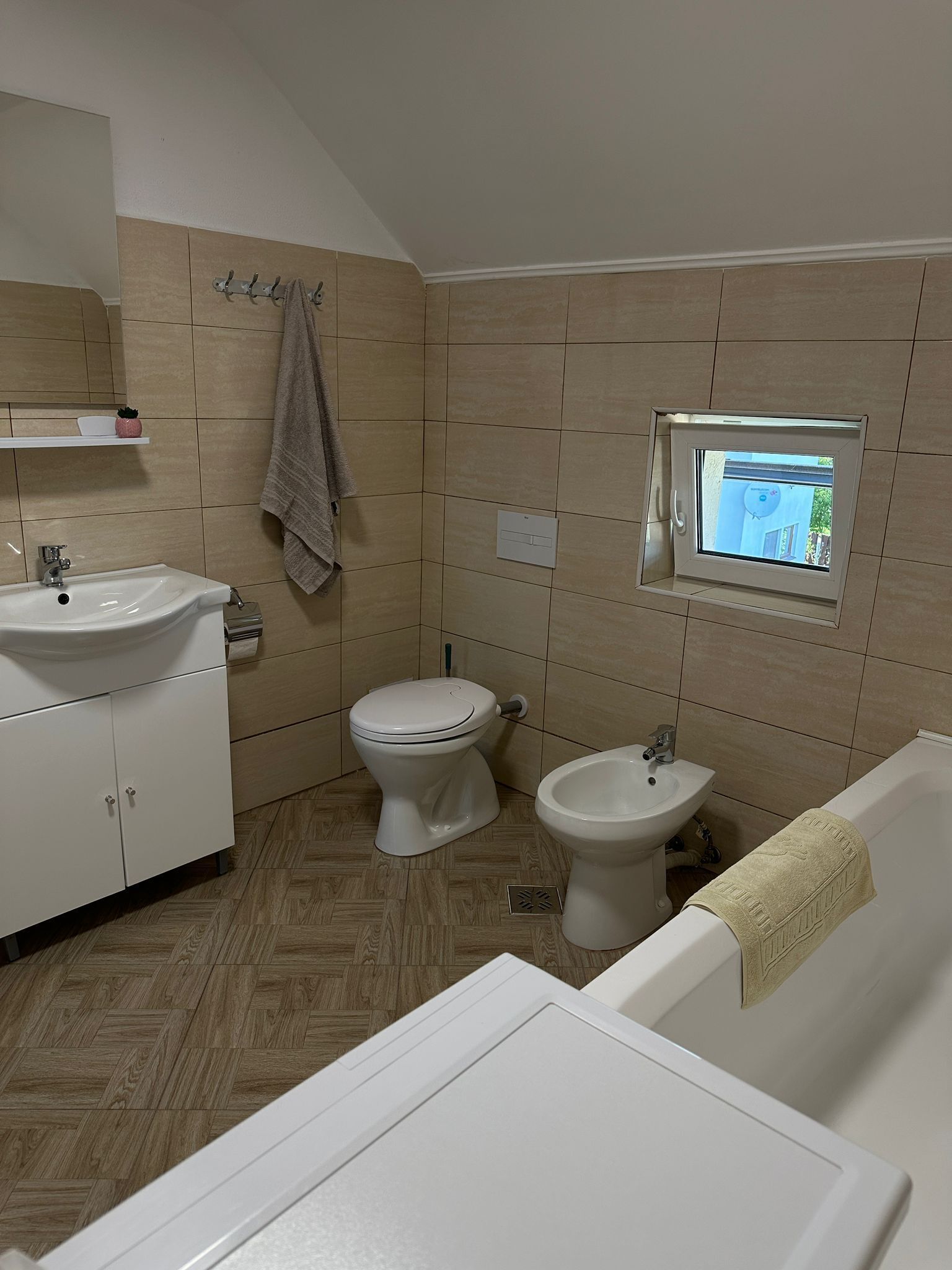 A bathroom with a toilet, bidet, sink, and bathtub.
