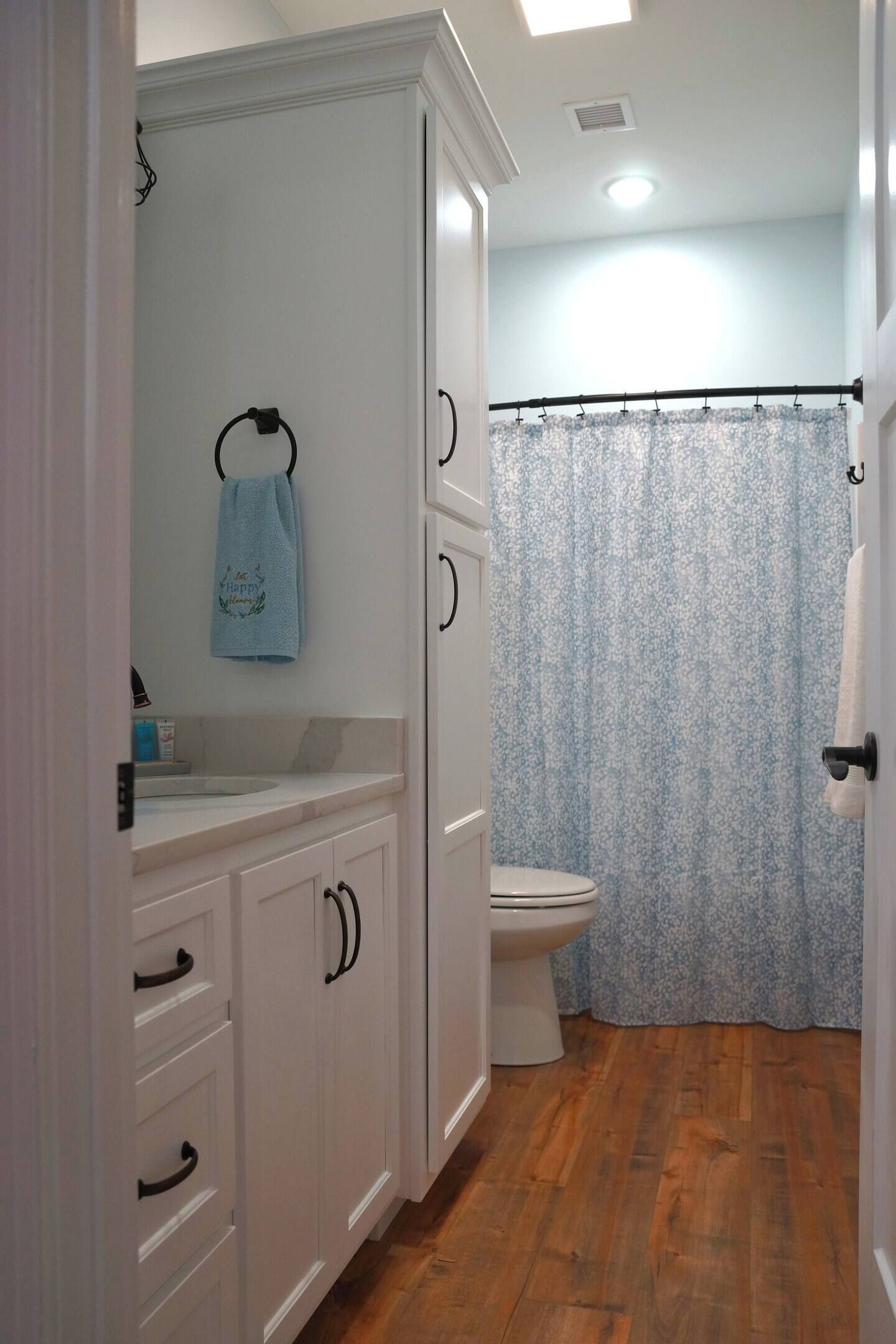 Une salle de bain avec des toilettes, un lavabo et un rideau de douche.
