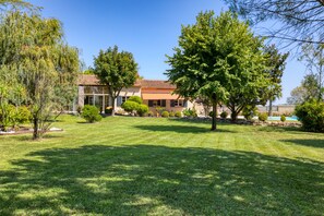 A house with a well-maintained lawn, a large tree, and a clear blue sky. - Country House 'L'évaroma' with Private Pool, Wi-Fi and Air Conditioning (Campagne)