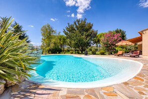 A swimming pool with stone tiles, surrounded by greenery and a clear sky. - Country House 'L'évaroma' with Private Pool, Wi-Fi and Air Conditioning (Campagne)