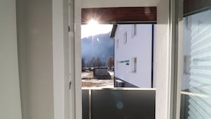 A view through a door with a building labeled "CHERSTUDIO" in the background, a mountain, and a clear sky. - Pöckau 32 Smart Rooms Self Check In (Arnoldstein)