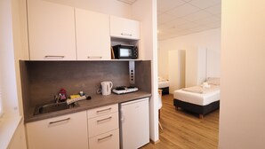 A compact kitchenette with a microwave, sink, and small refrigerator. - Pöckau 32 Smart Rooms Self Check In (Arnoldstein)
