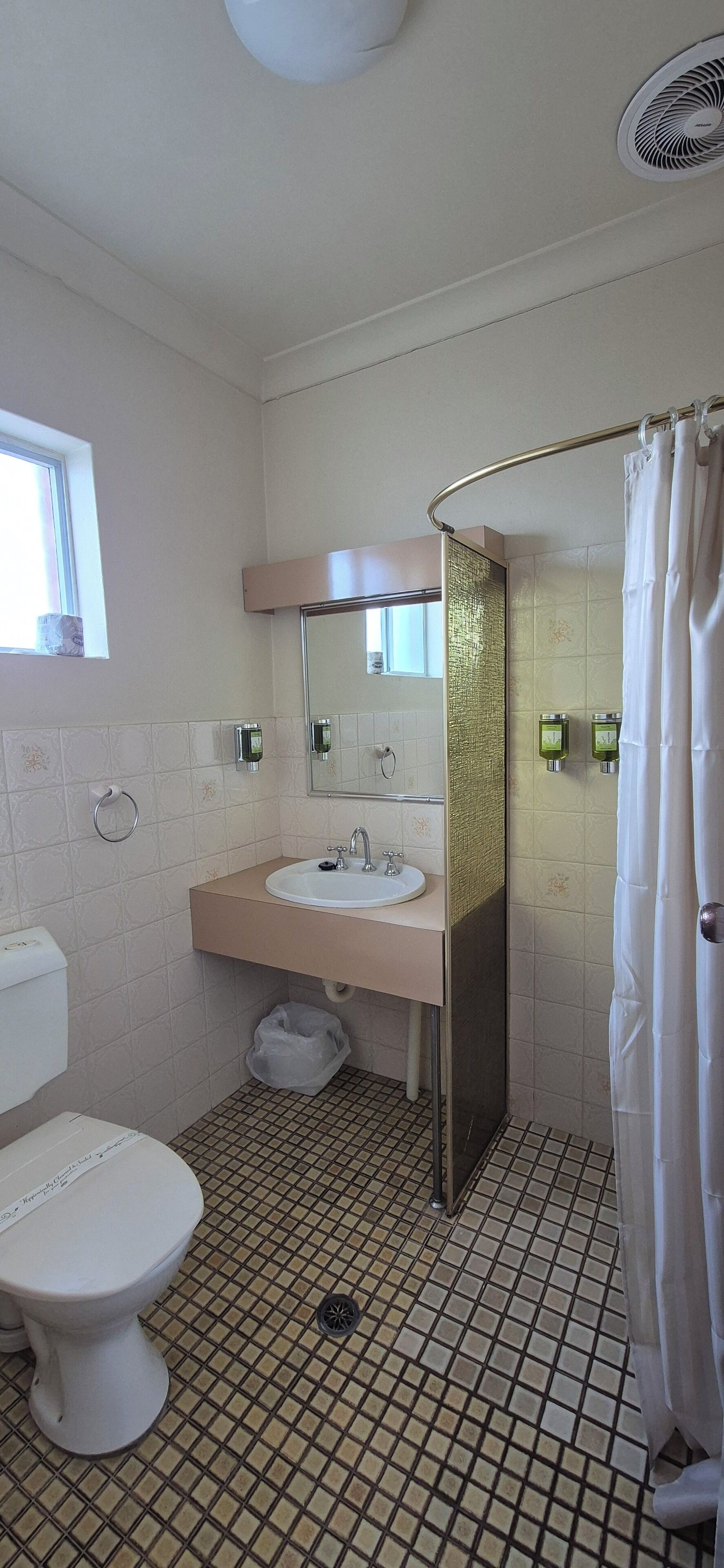 Een badkamer met toilet, wastafel en douche.