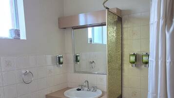 Een badkamer met toilet, wastafel en douche.