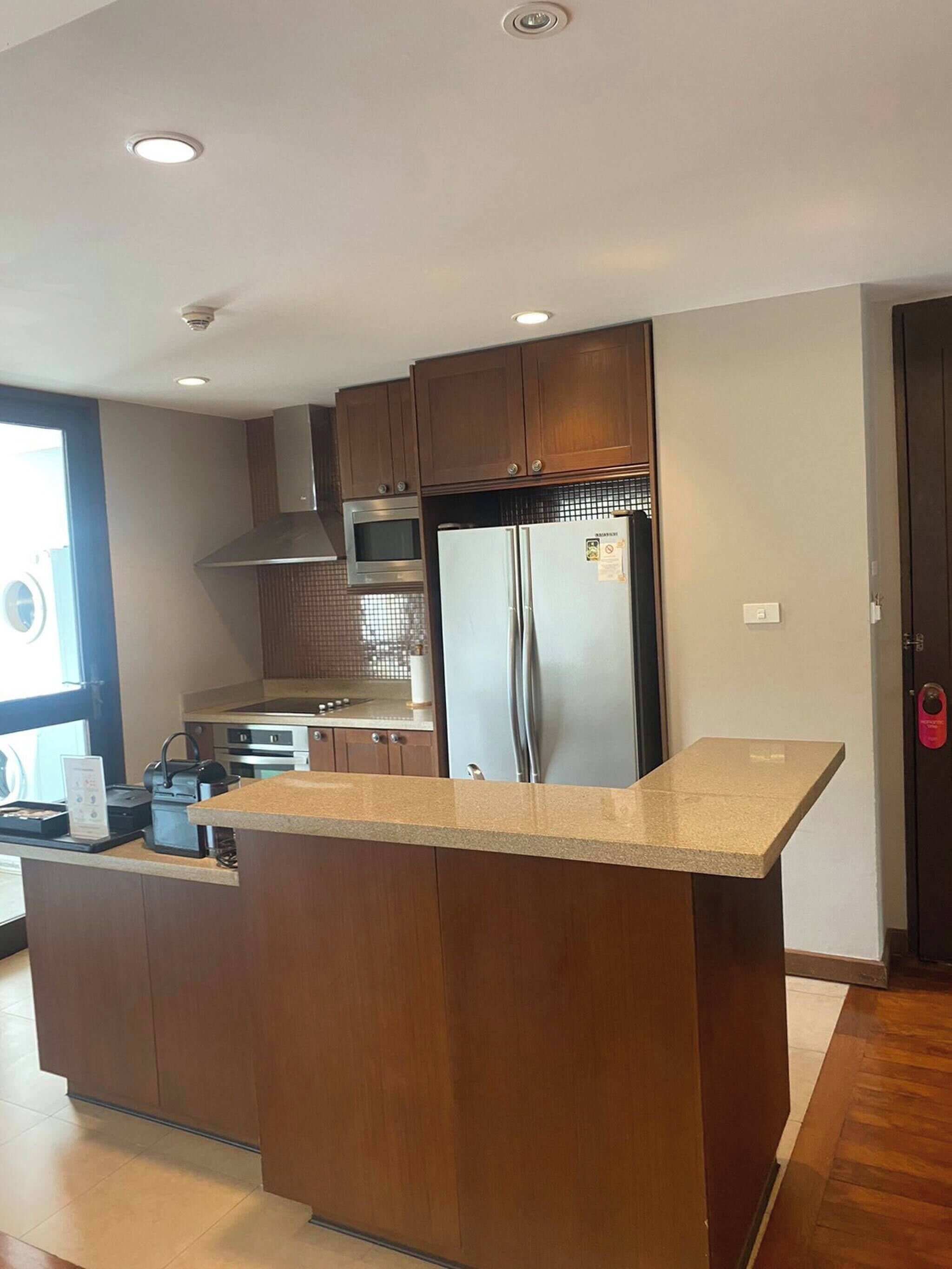 A modern kitchen with wooden cabinets, stainless steel appliances, and a granite countertop.
