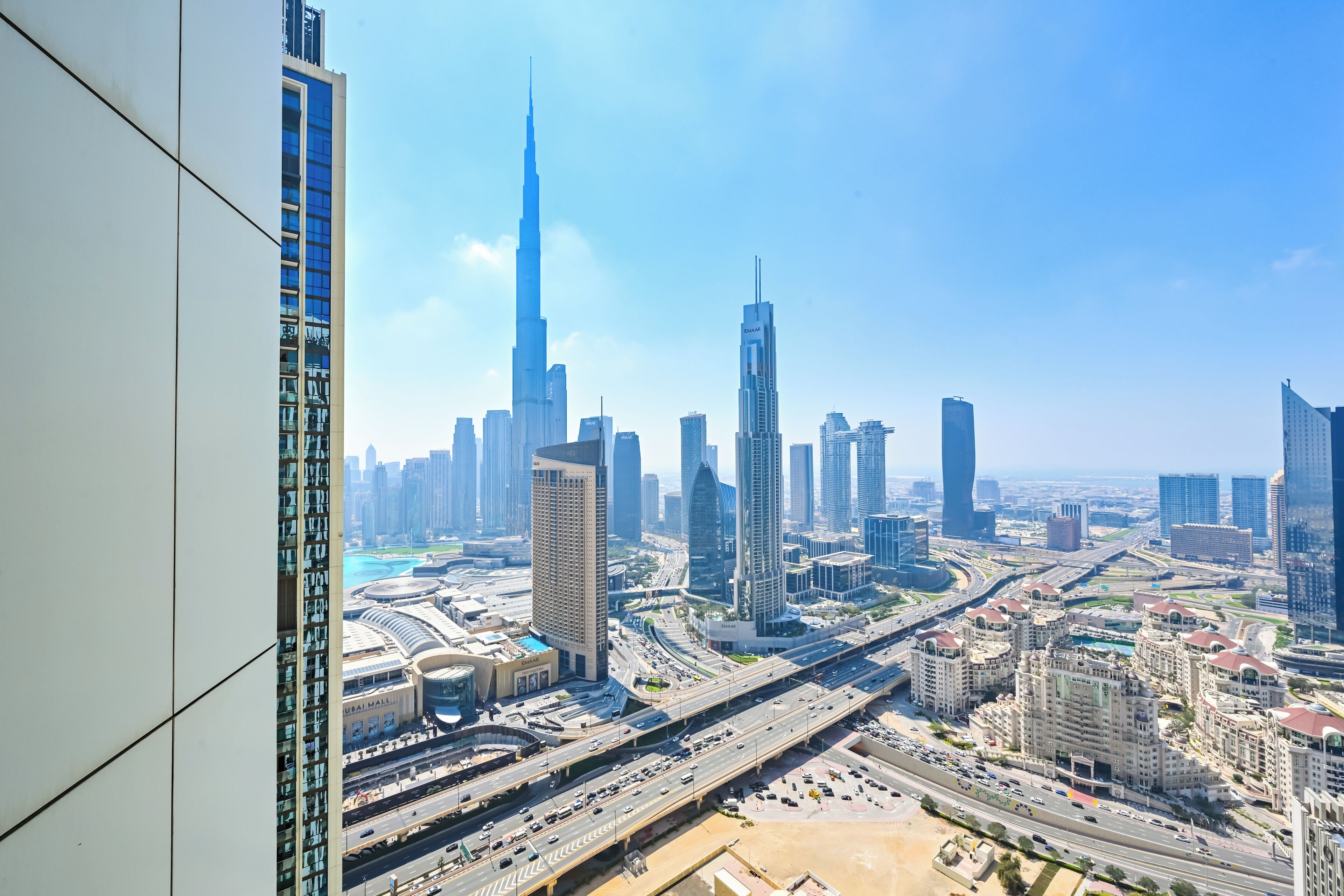 A cityscape with modern high-rise buildings, including a prominent skyscraper, and a network of roads.