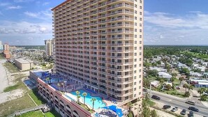 A high-rise hotel with multiple balconies, a rooftop pool area, and a view of the surrounding cityscape. - SUNRISE BEACH 2105, 2 BED 2 BA. balcony hOt TUB PoolS! (panama city beach)