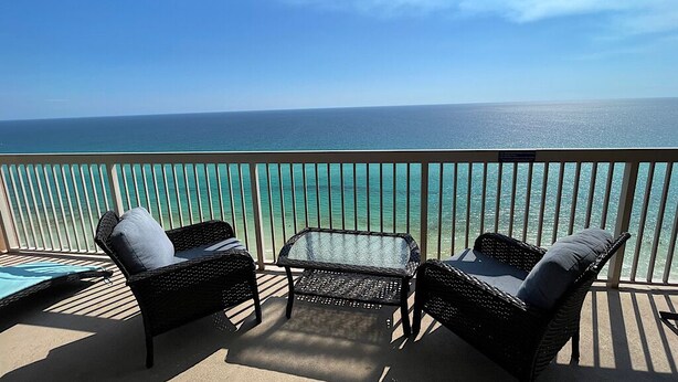 A balcony with wicker furniture and a view of the ocean. - SUNRISE BEACH 2105, 2 BED 2 BA. balcony hOt TUB PoolS! (panama city beach)