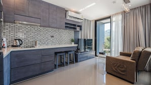 Una cocina moderna con salpicadero de azulejos, armarios de madera oscura e isla integrada con taburetes.