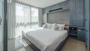 Un dormitorio moderno con una cama grande, televisión integrada y un diseño elegante.