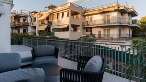 Un immeuble résidentiel doté de balcons, d’un espace extérieur aménagé et d’une entrée sécurisée par un portail.