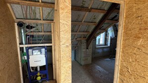 Un sitio de construcción con estructura de madera expuesta y aislamiento.