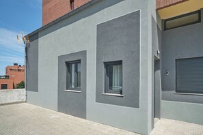 A modern building with two windows and a garage door.