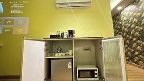 A compact kitchenette with a refrigerator, microwave, and coffee maker. - Sunrise studio 2 (Delhi)