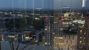 Un edificio alto con vista a un paisaje urbano al anochecer.