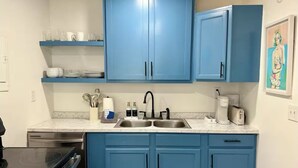 A kitchen with blue cabinets, a double sink, and a stove. - Cozy and Convenient- 5 min to Airport (North Charleston)
