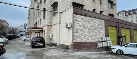 A multi-story building with a flat facade, several air conditioning units, and a ground-level entrance.