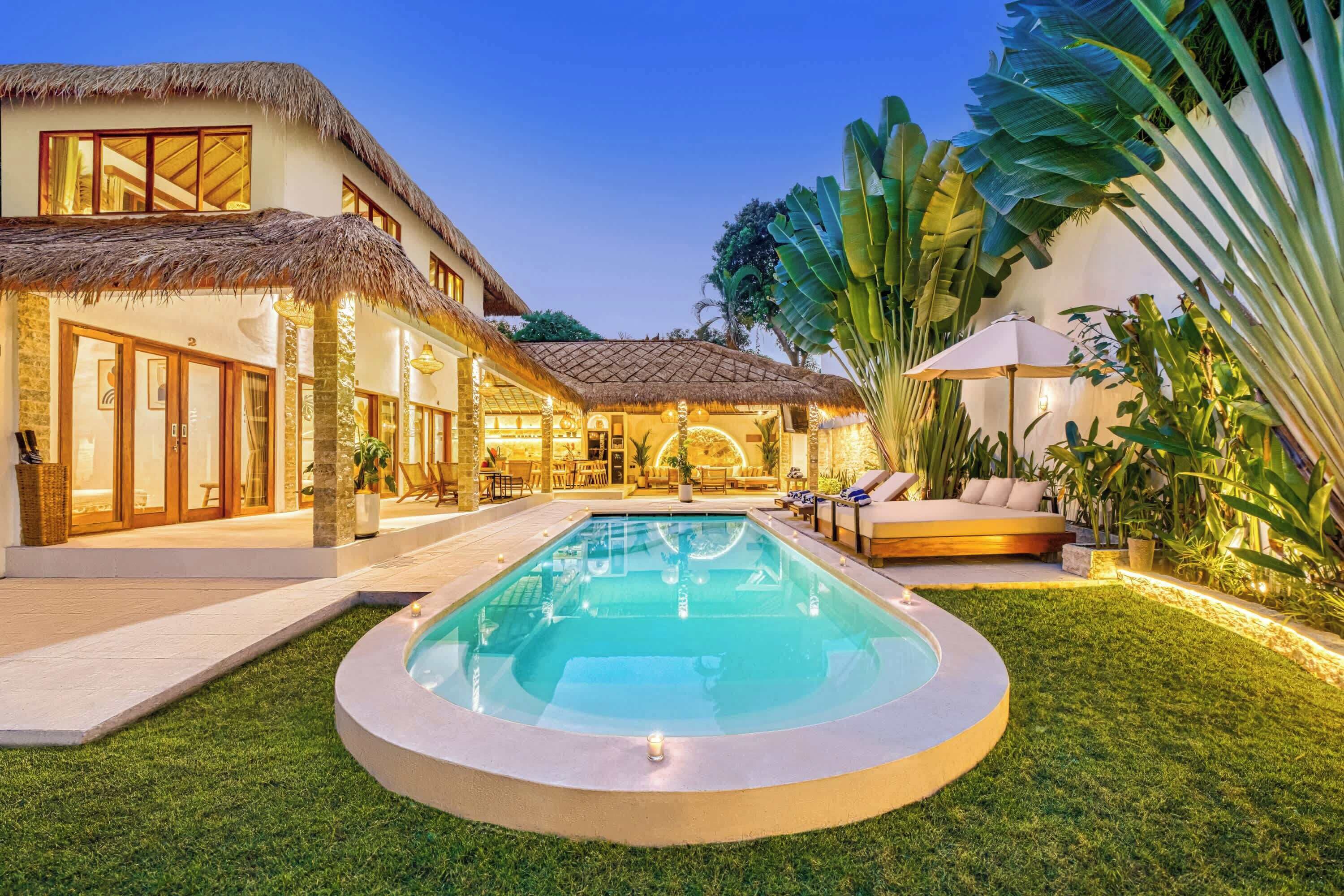 Une villa moderne dotée d’une piscine, d’un espace salon extérieur et d’une végétation tropicale luxuriante.
