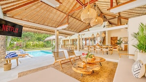 A spacious indoor area with a pool, lounge chairs, and a Netflix sign.