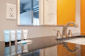 Un bagno con lavandino, specchio e articoli da toilette.