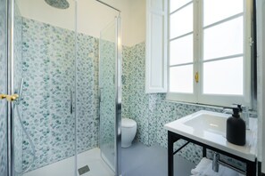 A bathroom with a glass shower enclosure, a toilet, and a sink with a mirror. - SALOTTO BORBONICO - SANFELICE (Naples)