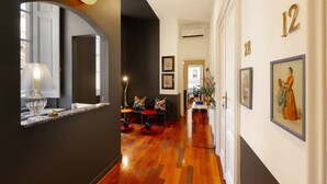 A hallway with a wooden floor, a sofa, a table, and a lamp. - SALOTTO BORBONICO - SANFELICE (Naples)