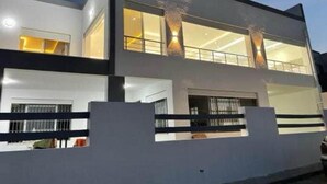 A modern two-story house with large windows and a balcony. -  3-bedroom apartment in Sounine (Sounine)