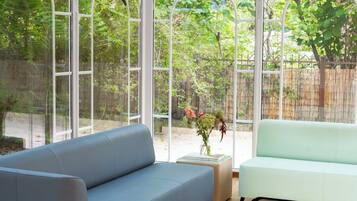 A modern living room with a blue sofa, a light green sofa, and a glass coffee table.