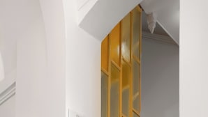 Uma escadaria com corrimão dourado e uma placa indicando os quartos 101 a 103.