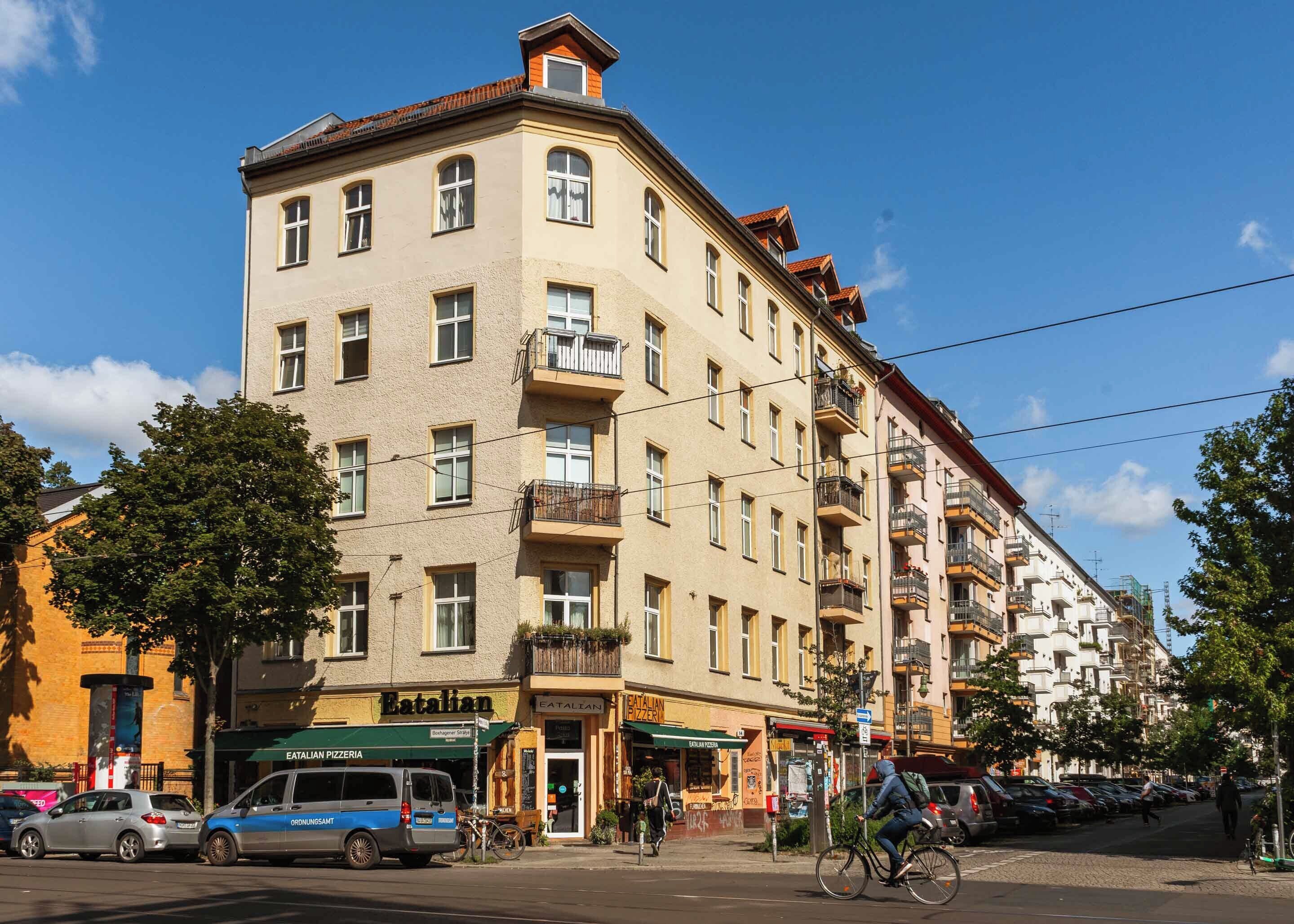 A multi-story building with a ground-floor pizzeria and a visible entrance.
