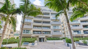 A multi-story residential building with balconies, a paved courtyard, and palm trees. - Beautiful 3BR Stay w/private terrace in St Julians (St. Julian`s)
