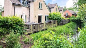 Eine Reihe von Häusern mit Holzbalkon und Garten davor.