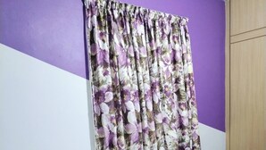 A room with a bed, purple walls, and a floral curtain. - Cosy Home in Damansara (Sungai Buloh)