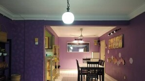 A dining area with a table and chairs, a ceiling fan, and a light fixture. - Cosy Home in Damansara (Sungai Buloh)