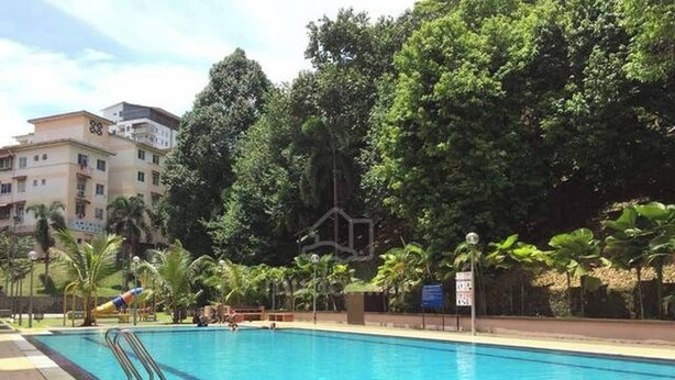 A swimming pool with clear blue water, surrounded by palm trees and a building in the background. - Cosy Home in Damansara (Sungai Buloh)