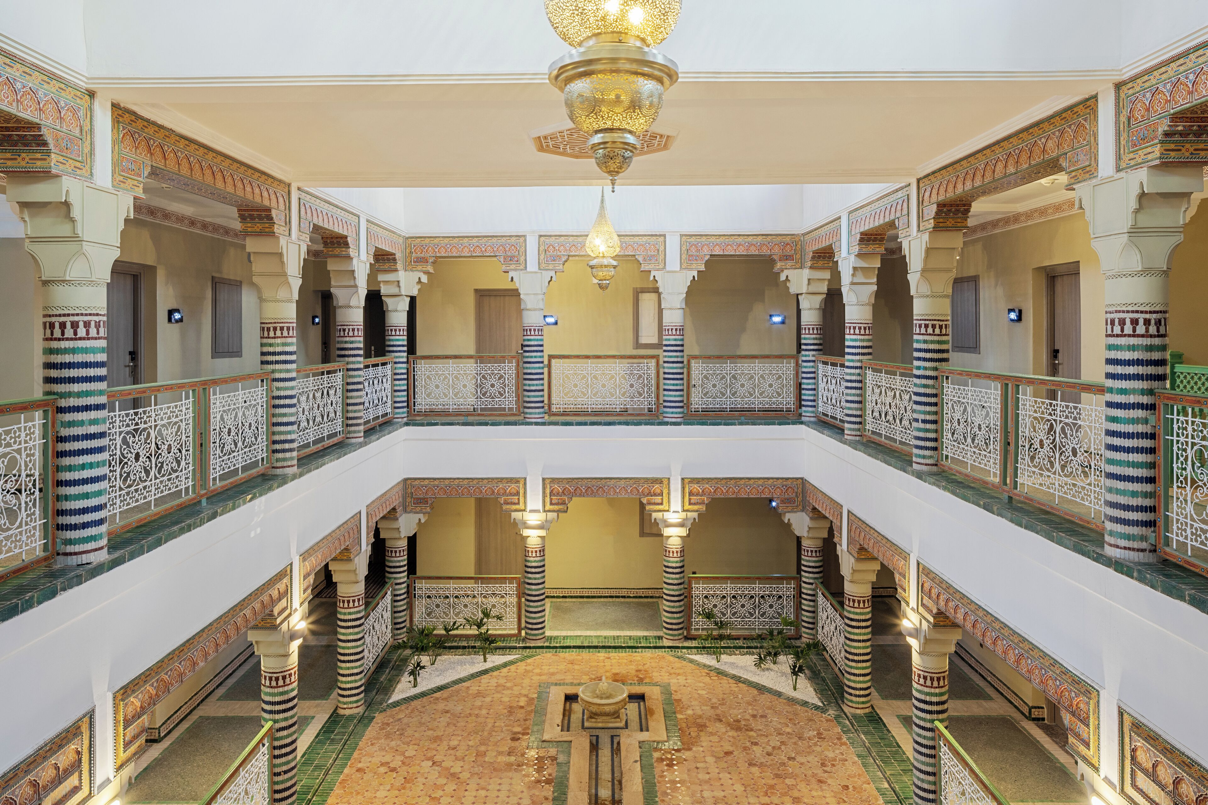 Ein mehrgeschossiges Interieur mit aufwendigen Bögen, Säulen und einem zentralen Innenhof.