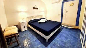 Une chambre à coucher avec un lit, une table de chevet et une armoire.