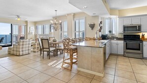 A spacious kitchen with a large island, white cabinetry, and modern appliances.