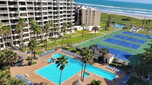 A hotel with multiple floors, a swimming pool, tennis courts, and a beach view. - Beachfront Hotspot - New Furnishings - Pool - 1st Floor (South Padre Island)