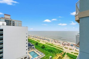 Vistes d'una platja amb piscina i gandules.