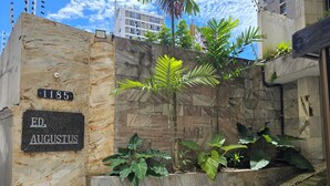 Un mur de pierre sur lequel est fixée une plaque portant l’inscription « 1185, ÉDIT D’AUGUSTE » et un jardinier avec des plantes vertes.