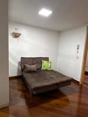 A room with a single bed, a hanging light fixture, and a door. - Elegant and spacious studio in an upscale neighborhood of Belém. (Nazaré Belém)