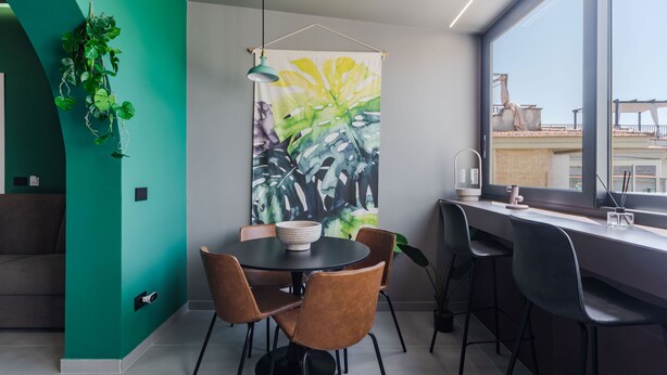 A modern dining area with a round table, four chairs, and a large abstract painting on the wall. - Terrace Jacuzzi - Tropicalia by Wonderful Italy (Aci Castello)