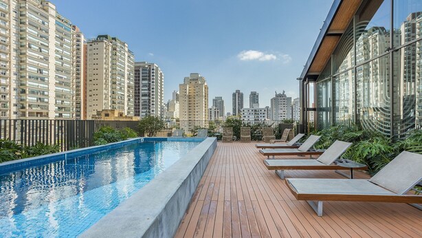 A rooftop pool with lounge chairs and a city view. - Full Studio 1km From Puc-sp Aby40002 (São Paulo)